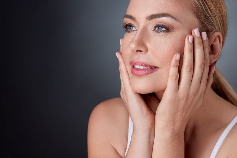 Pleased woman touching face